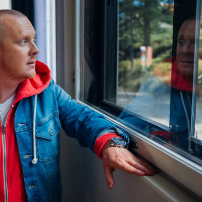 Lasse Mellberg tittar ut från fönster.