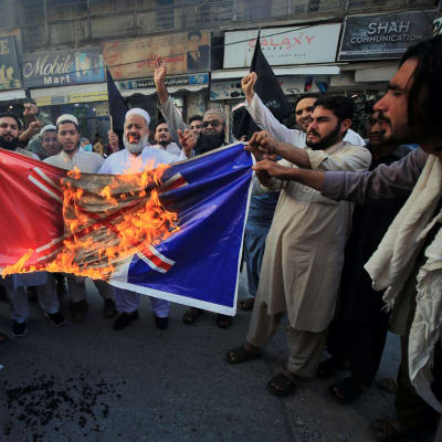 Pakistani people burn a mock of a French flag during a demonstration against French President Macron's comments over Prophet Muhammad caricatures, in Peshawar, Pakisan, 26 October 2020. A group of protestors gathered to protest Macron's comments following the recent beheading of a teacher in France, after he had shown caricatures of the Prophet Muhammad in class. Macron vowed his country would not give up publishing such cartoons. EPA-EFE/ARSHAD ARBAB