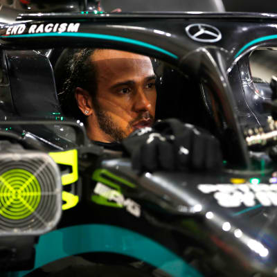 Lewis Hamilton istuu kisan jälkeen Mercedeksen F1-autossa.