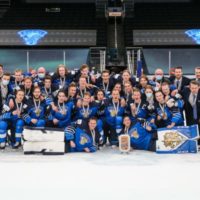 Nuorten Leijonien pronssijoukkue yhteiskuvassa jäällä.
