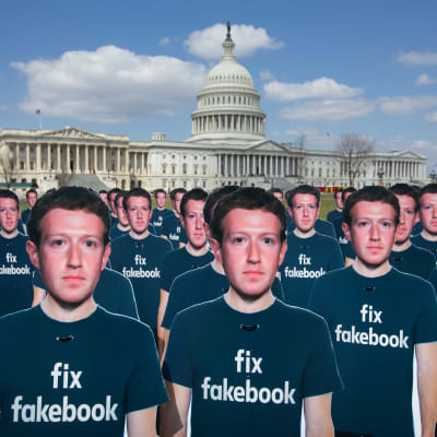 Mark Zuckerbergin pahvihahmojen t-paidoissa lukee teksti "fix fakebook". Yhdysvaltain kongressirakennus taustalla.
