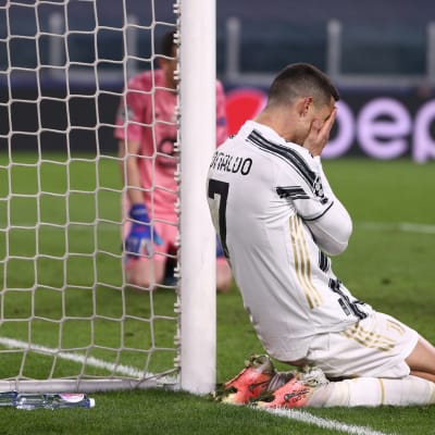 Christiano Ronaldo polvillaan kentän laidalla ja kädet kasvojen edessä. 