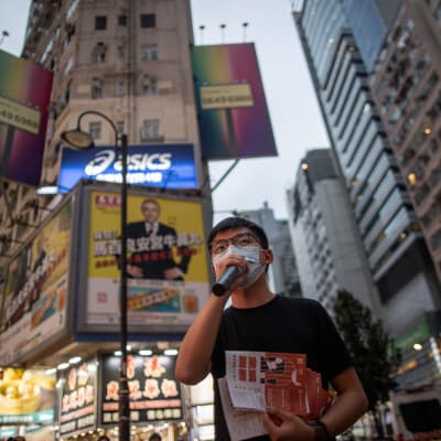 Hongkongin demokratia-aktivisti Joshua Wong Chi-fung  jakaa lentolehtisiä. 