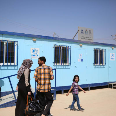 Ihmisiä YK:n pakolaisjärjestö UNHCR:n toimipisteen edessä Zaatarin pakolaisleirillä. 