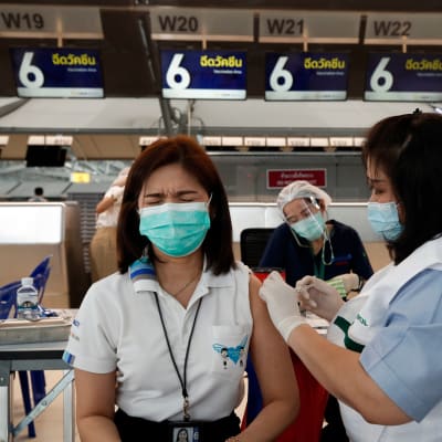 Lentomatkailualan työntekijöitä rokotettiin matkustajista tyhjentyneellä Bangkokin lentoasemalla huhtikuussa.
