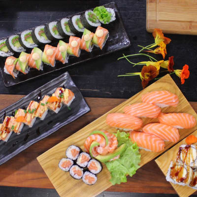 Olika portioner av sushi på ett bord i ett kök