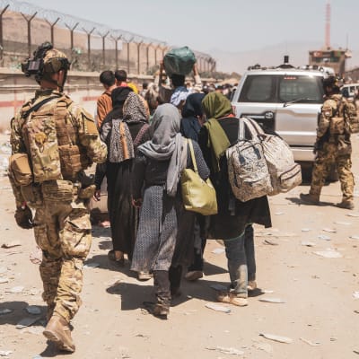 Sotilaat ohjasivat evakuoitavia Kabulin lentokentällä tiistaina.