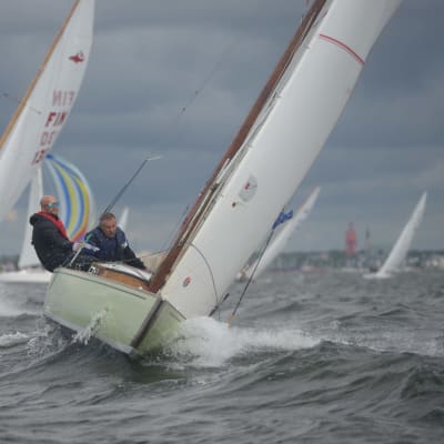 Två segelbåtar med personer ombord tävlar mot varandra på Hangöregattan. Det blåser och är vågor.
