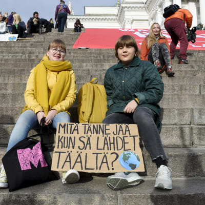 Demonstranter väntar på att klimatmarschen ska börja på Domkyrkans trappa i Helsingfors.