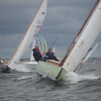 Två segelbåtar med personer ombord tävlar mot varandra på Hangöregattan. Det blåser och är vågor.