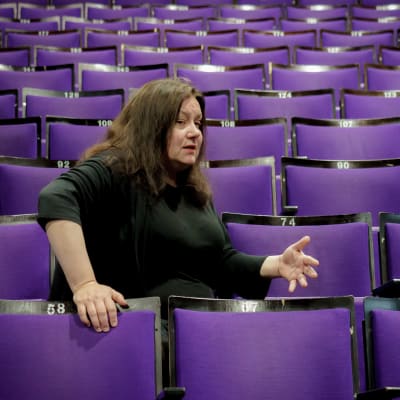 Toimittaja, teatteriohjaaja Susanna Kuparinen tyhjässä teatterikatsomossa.