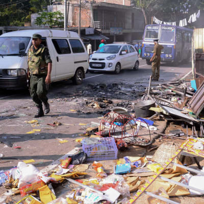polis i Sri Lanka utanför en förstörd butik i distriktet Kandy 6.3.2018.