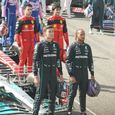 Charles leclerc och Carlos Sainz står bakom George Russell och Lewis Hamilton.