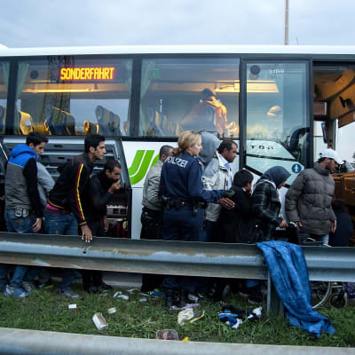 Flyktingar köar för att komma på bussar från Ungern till Österrike
