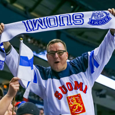 En supporter håller i en flagga med texten Finland.
