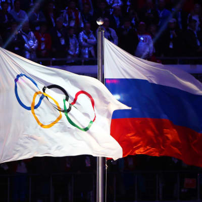 Olympialaisten lippu ja Venäjän lippu liehuvat vierekkäin.