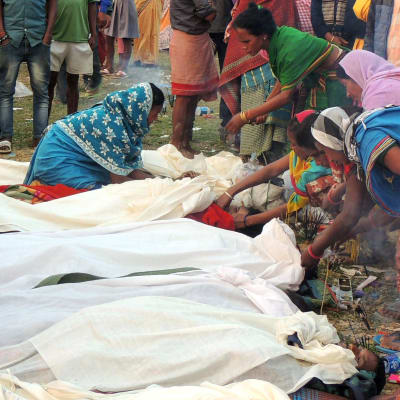 Kvinnor samlade runt dödsoffren i en by i distriktet Golaghat, i Assam, i fredags den 22 februari.