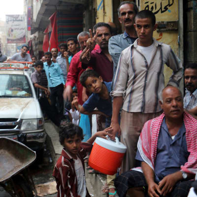 Jemeniter köar för att köpa mat och vatten i Taiz, Jemen, den 19 juni.