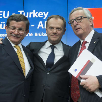 Turkiets premiärminister Ahmet Davutoğlu, Europeiska rådets ordförande Donald Tusk och EU-kommissionens ordförande Jean-Claude Juncker den 18 mars då EU och Turkiet slöt sitt flyktingavtal.
