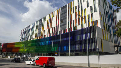 Färgrann fasad på en stor vit sjukhusbyggnad. 