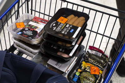 Rödmärkta köttprodukter i en shoppingkärra.
