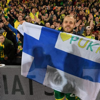 Teemu Pukki juhlii Norwichin nousua Suomen lipun kanssa.