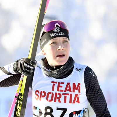 Kaisa Mäkäräinen kantaa suksia hiihdettyään SM-kisoissa.