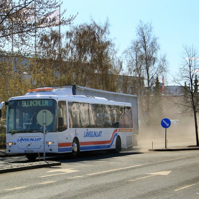 Buss drar uppdammoln efter sig.