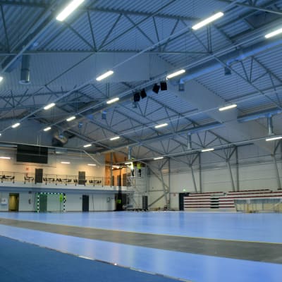 En översiktsbild på en stor allaktivitetshall med blått golv.