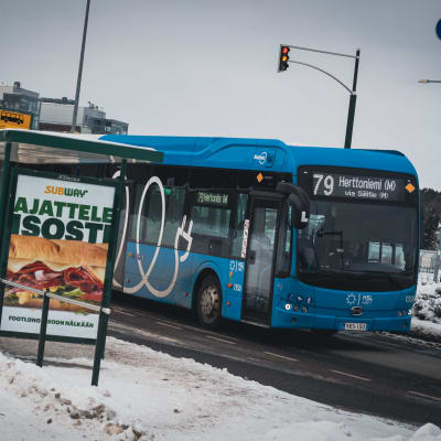 Busslinje 79 i ett vinterlandskap vid en hållplats i Vik i Helsingfors.
