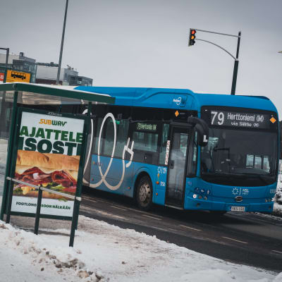Busslinje 79 i ett vinterlandskap vid en hållplats i Vik i Helsingfors.