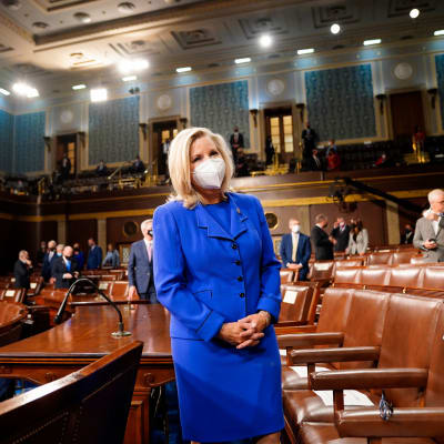 Maski kasvoillaan oleva Liz Cheney seisoo yksin kongressin istuntosalissa.
