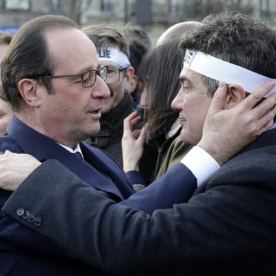 Frankrikes president Francois Hollande kramar en kolumnist vid Charlie Hebdo under manifestationen mot terrorism i Paris 11.1.2015
