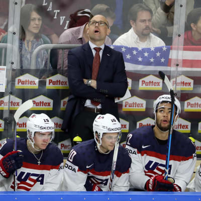 Jeff Blashill står och tittar upp, framför honom sitter några spelare på bänken
