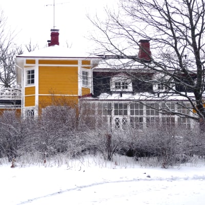 Villa Snäcksund, gulmålad trävilla, i vinterskrud