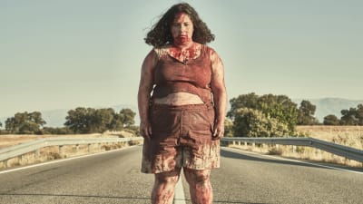 Sara (Laura Galán) står blodig mitt på vägen och ser rakt in i kameran.