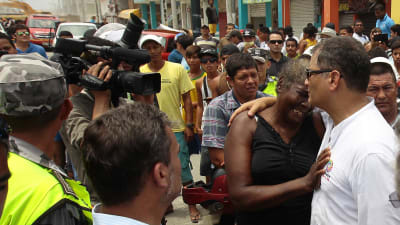 Ecuadors president Rafael Correa (till höger) tröstar en kvinna i den skalvdrabbade staden Pedernales 18.4.2016