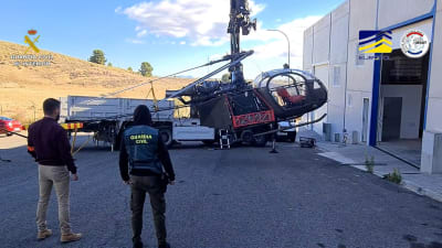 Polisen lastar en helikopter på ett flak i Spanien.