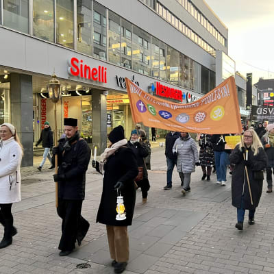 Jyväskylän eri uskontojen ja katsomukset edustajat yhteisellä marssilla Kävelykadulla. Lakanassa lukee, että "Uskot yhteiskuntarauhan puolesta".
