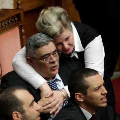 Gyllene grynings partiledare Nikos Michaloliakos omfamnas av sin hustru Eleni Zaroulia.