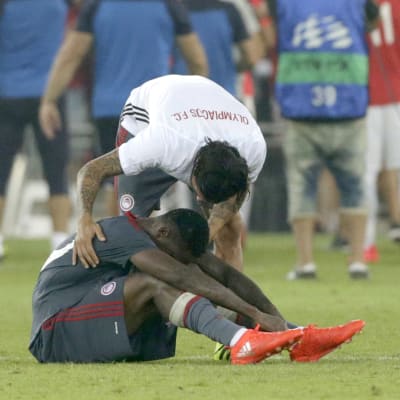 En Olympiakos-spelare tröstar en annan.