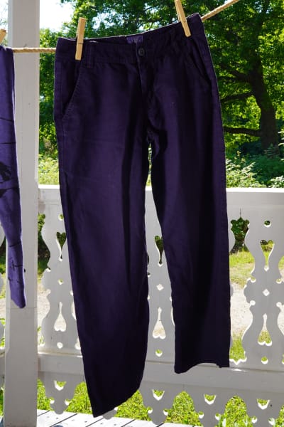 Ett par mörkblåa byxor som hänger på tork utomhus.
