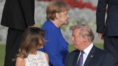 Melania och Donald Trump i förgrunden. I bakgrunden syns Angela Merkel.