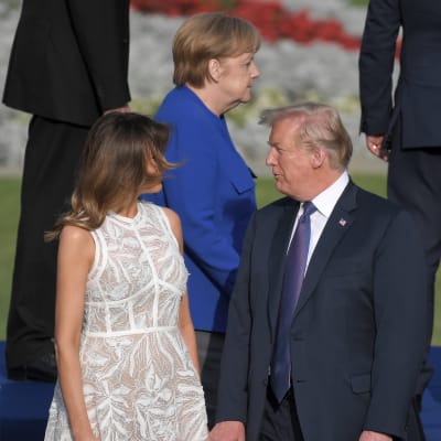 Melania och Donald Trump i förgrunden. I bakgrunden syns Angela Merkel.
