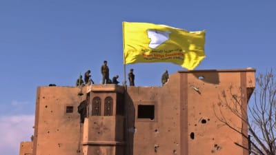 SDF reste som flagga över en byggnad i Baghouz på lördag morgon. 