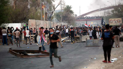 Demonstranter vid en barrikad vid lokalstyrets byggnad i Basra
