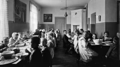 Helsinkiläisen Vallilan kansakoulun oppilaat kouluruokalassa vuonna 1913.