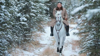 Kim Jong-un rider på en vit häst genom genom en snöig skog.
