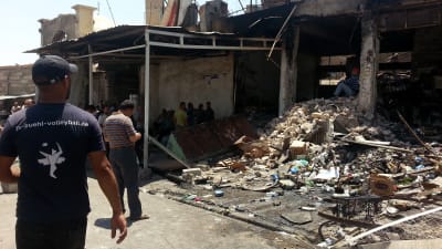 Irakier inspekterar skadorna efter armén flygräd mot Mosul 28.6.2014