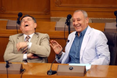 Kaksi vanhempaa miestä nauraa vitsille.